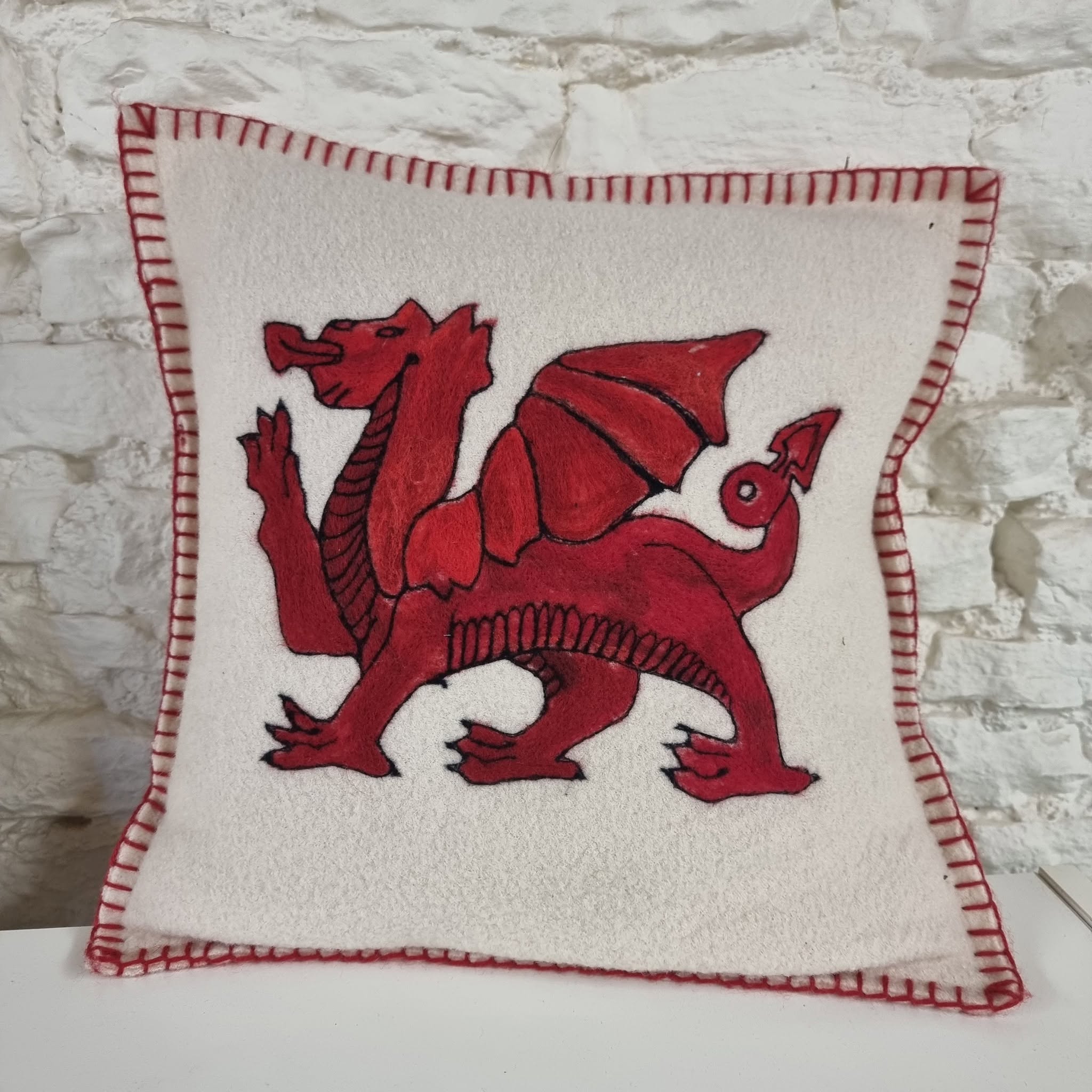 743484460_27052228181140161_1374045991518356955_n | Busy Bees Patchwork Close-up of white fabric patch with a red dragon embroidery and red blanket-stitch border.